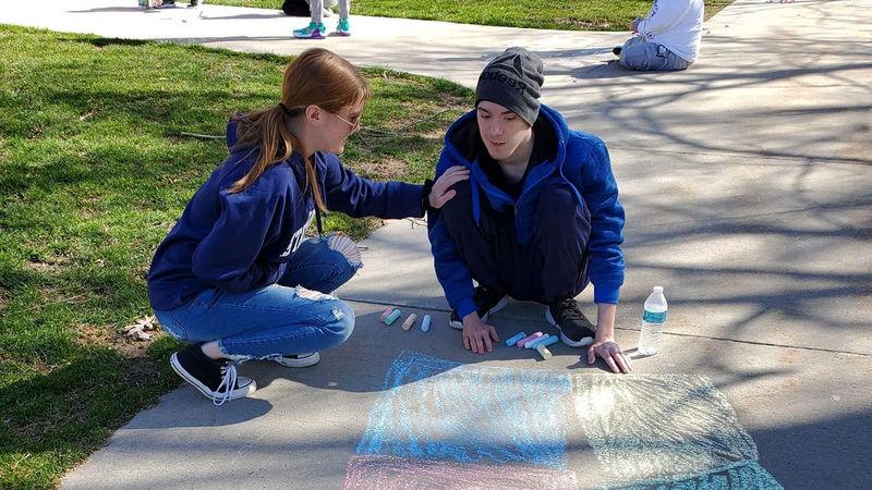 卡森和悉尼在十大网投平台信誉排行榜阿尔图纳分校学生组织“我们是朋友”举办的人行道粉笔活动上.
